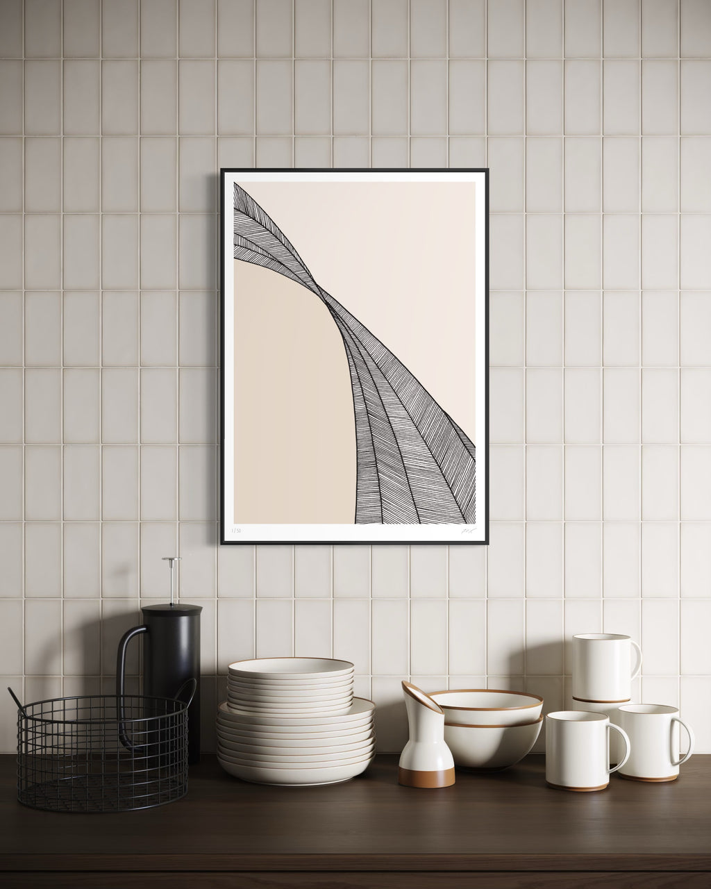 Framed abstract art on a wall above a wooden surface with kitchenware.