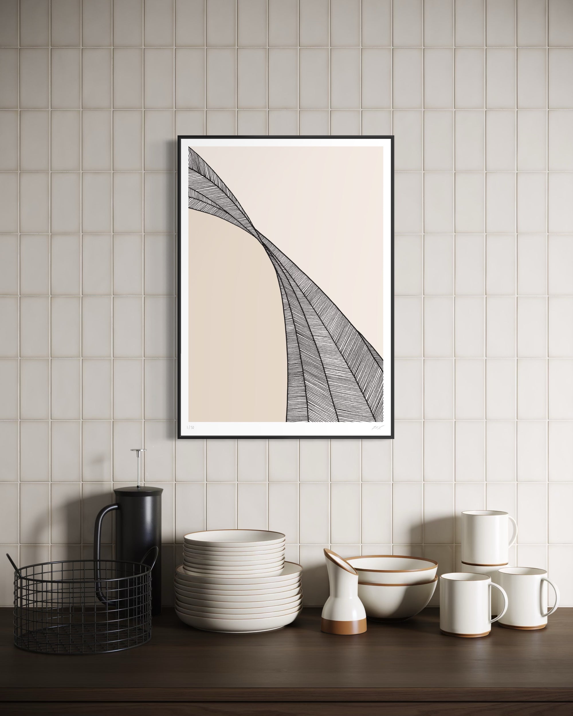 Framed abstract art on a wall above a wooden surface with kitchenware.