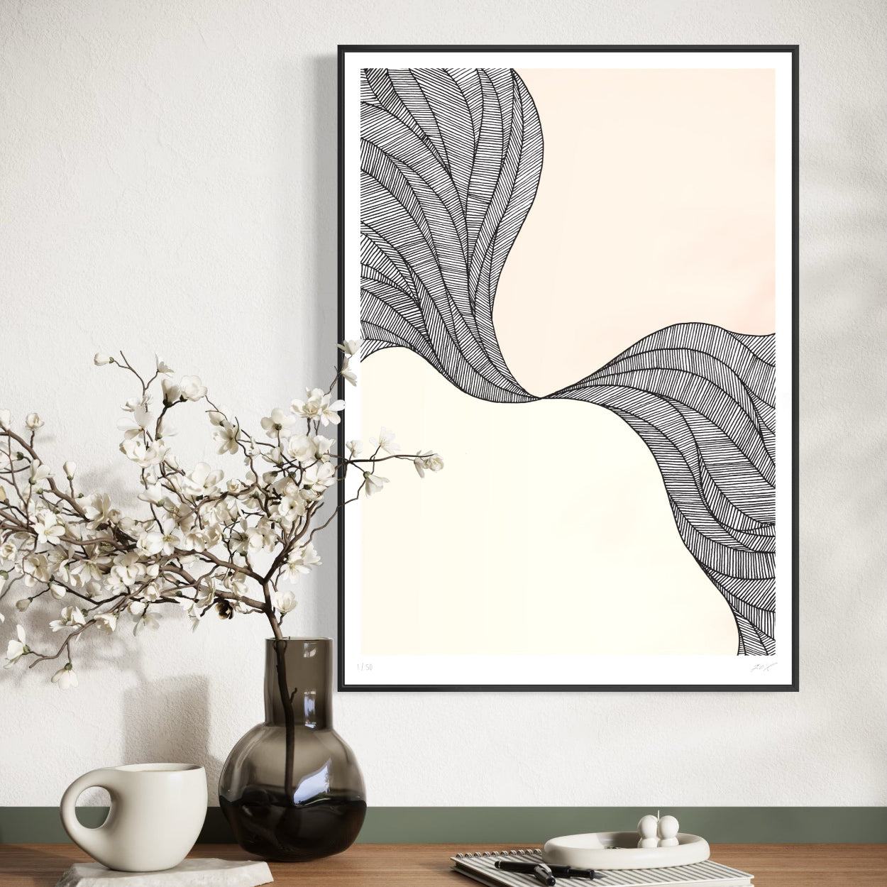 Framed abstract art print on a wall with decorative items below.