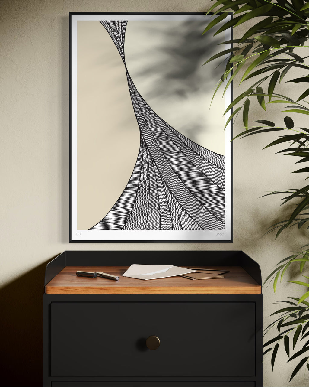 Framed abstract artwork on a wall above a black cabinet with wooden top.